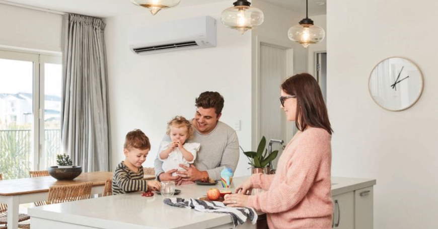 Roditelji s dvoje male djece uživaju u kuhinji u kojoj je temperatura vazduha regulisana klima uređajem na zidu